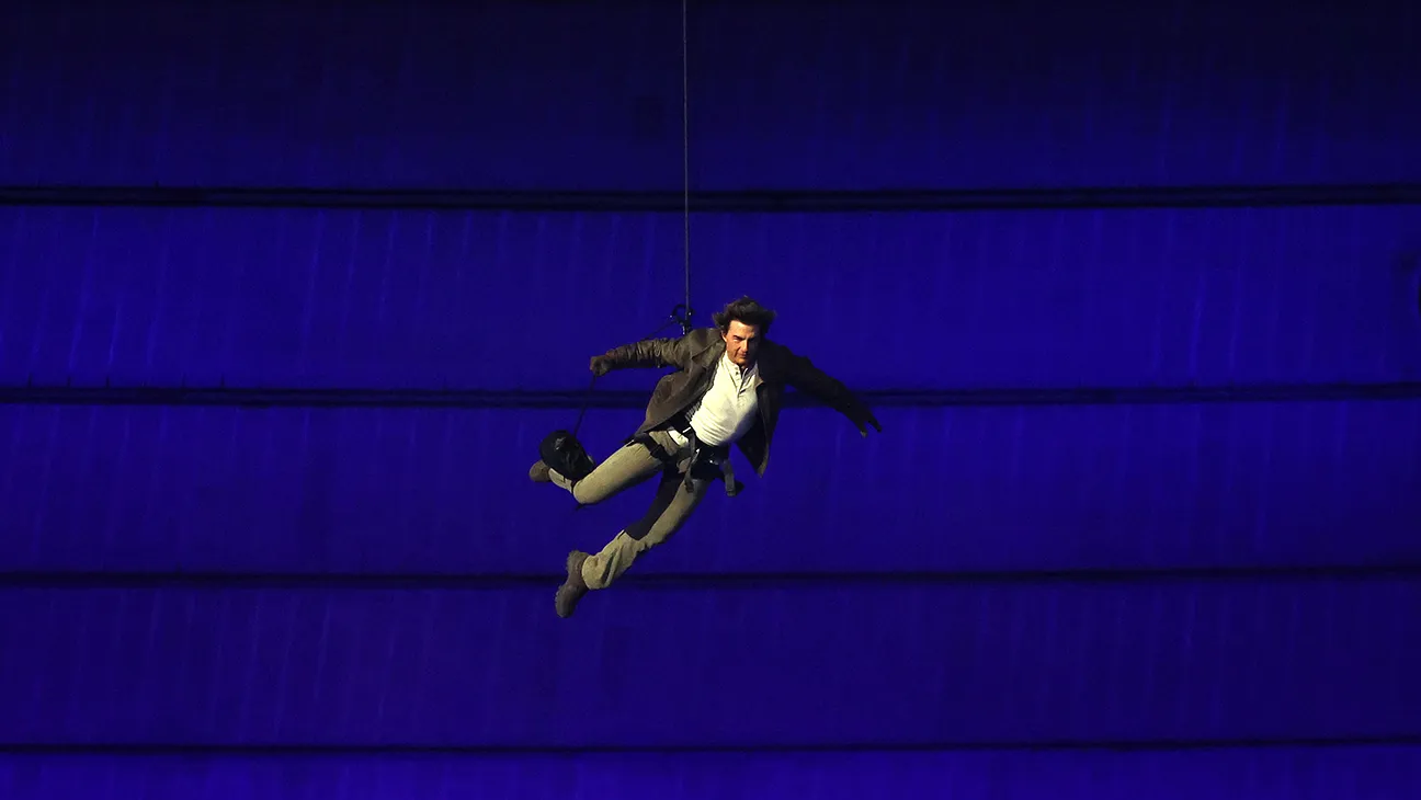 Tom Cruise made a dramatic entrance from the roof of Stade de France to retrieve the Olympic flag
