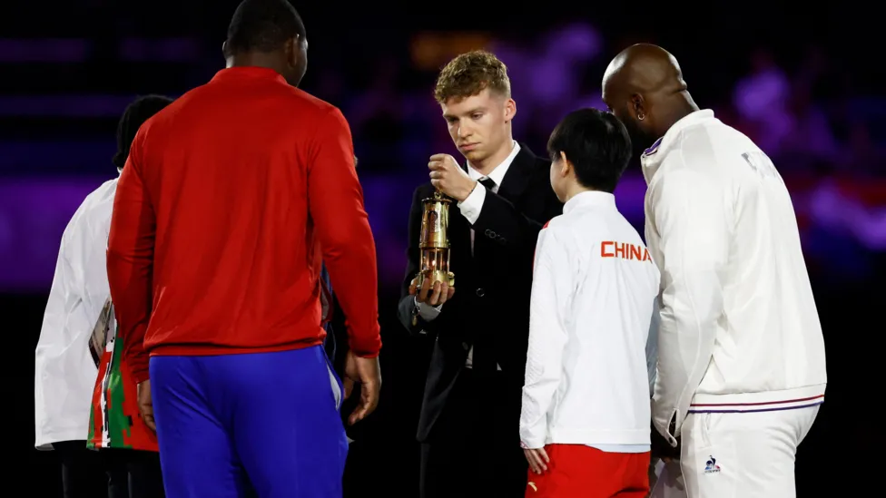 Thomas Marchand, joined by athletes from around the world and the Refugee Olympic Team, put out the Olympic flame, marking the end of the 2024 Games