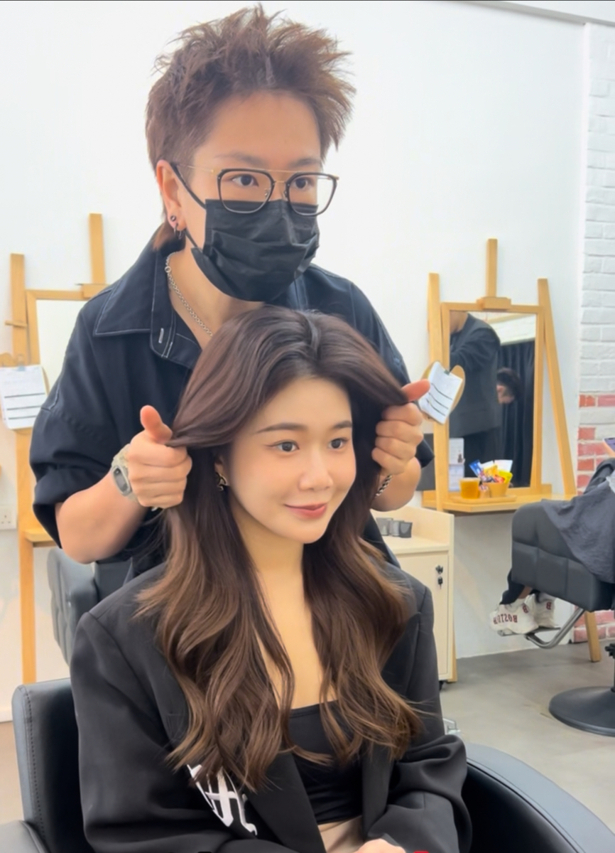 A perm specialist styling a customer’s hair