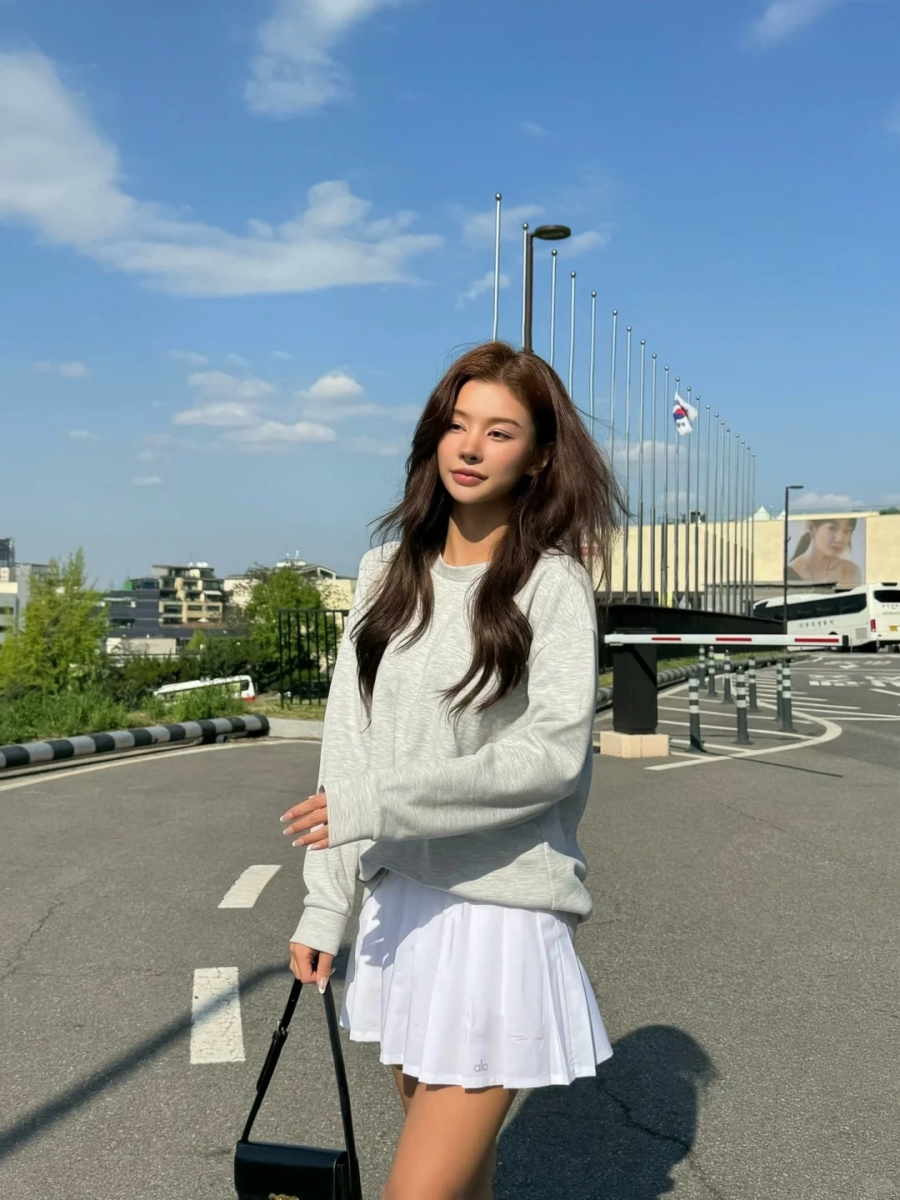 Pair your tennis skirt with an oversized sweater for a comfy, effortless, and stylish everyday look