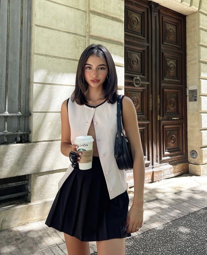 Style a sleeveless buttoned top with your skirt, leaving lower buttons undone for a classy waistline curve