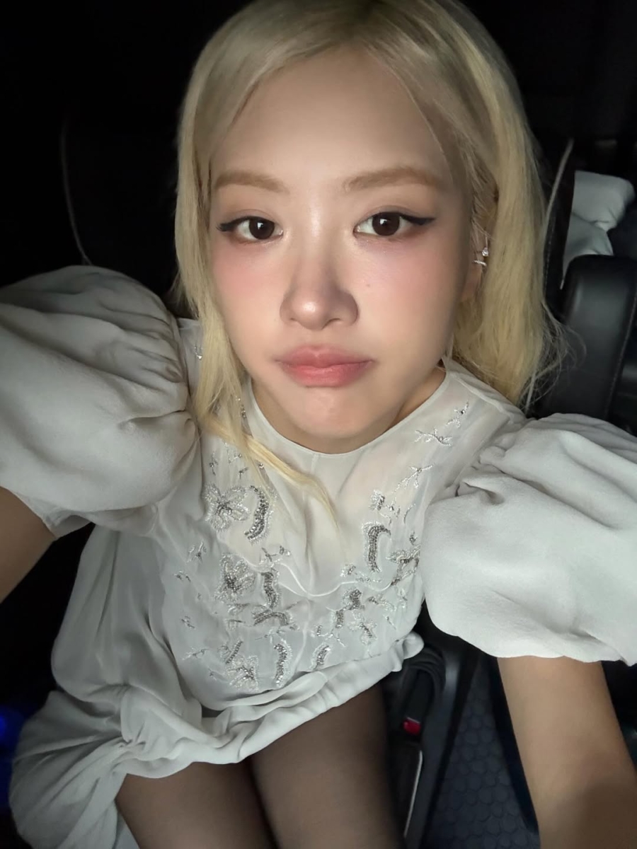 Rosé with winged eyeliner, flushed pink cheeks, and nude-pink lips